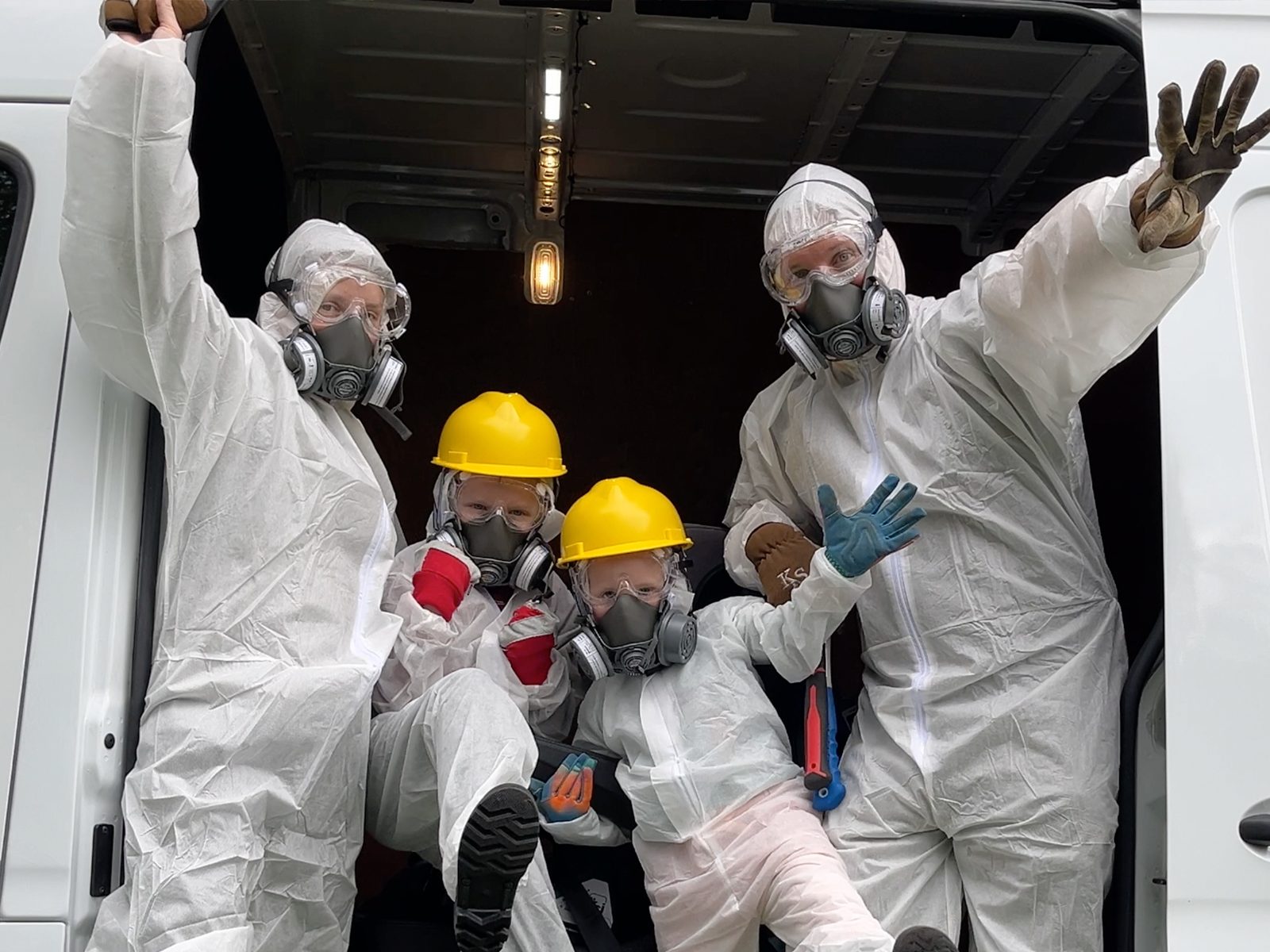 The whole family suited up in hazmat gear and respirators, ready for demolition day