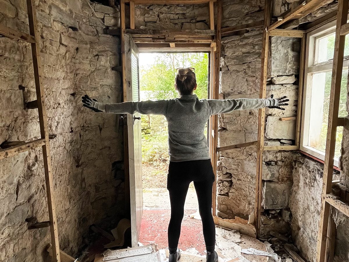 Carol standing in the gutted cottage on the Isle of Skye